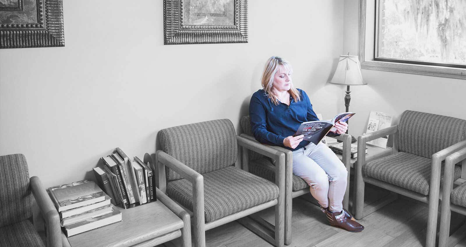 A patient reading a book at dental office