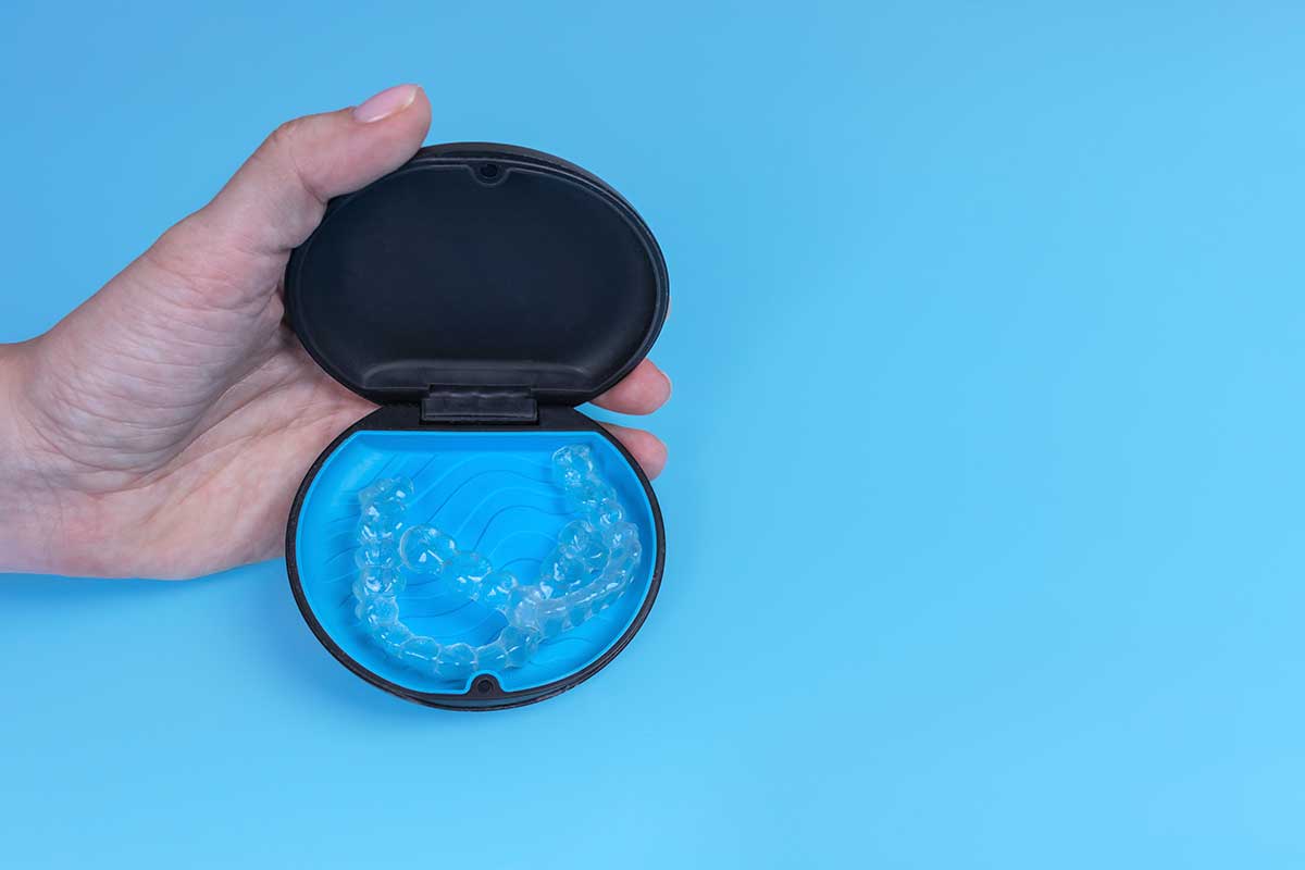Invisible transparent aligners in black container