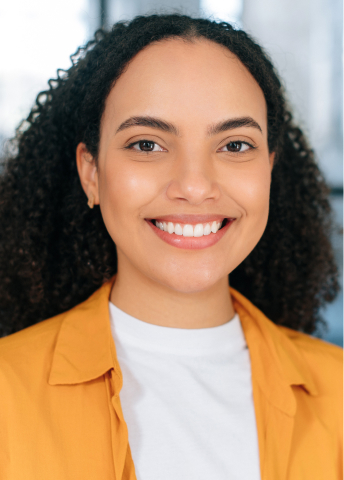Smiling woman in yellow jacket representing cosmetic dentistry services in Orlando, Florida.