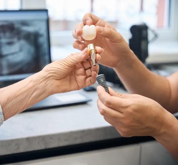 Dentist examining a dental implant crown with patient in Orlando office.