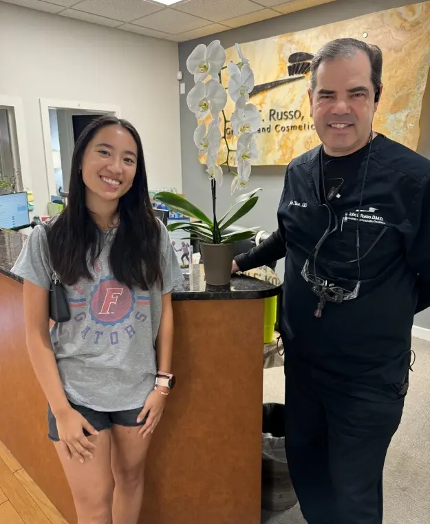 Young female patient smiling with male dentist in Orlando dental office.