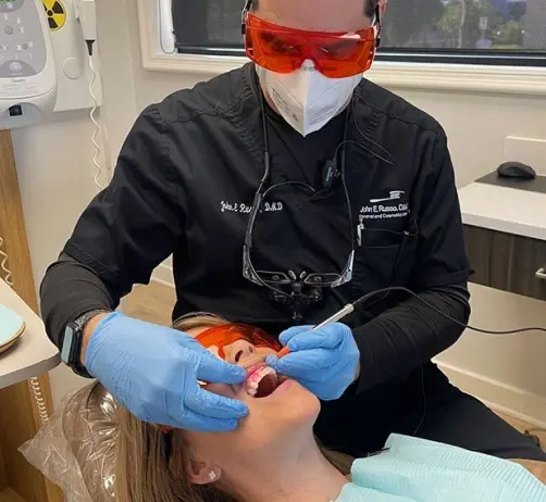 Dentist performing soft tissue laser treatment on patient's gums in Orlando dental office.