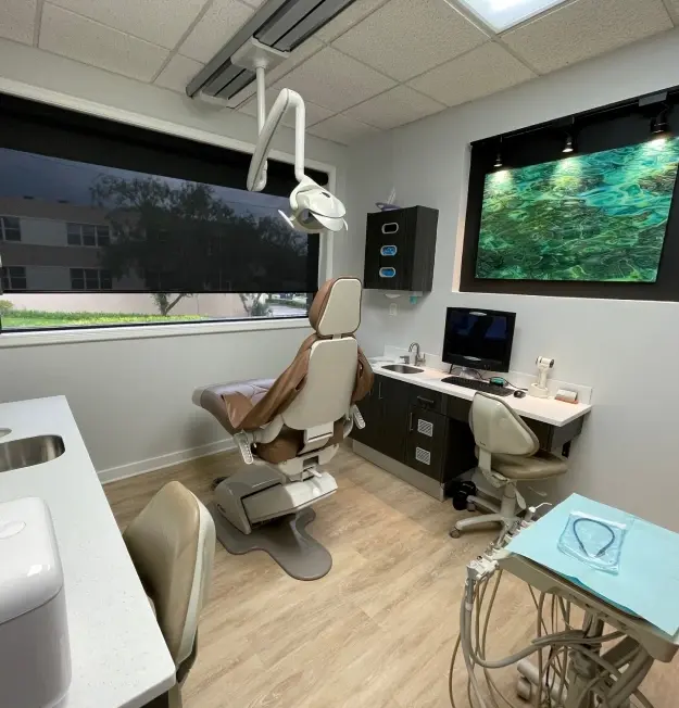 Modern dental operatory with patient chair, overhead light, digital displays, and treatment equipment at 430 N Mills Ave, Or.