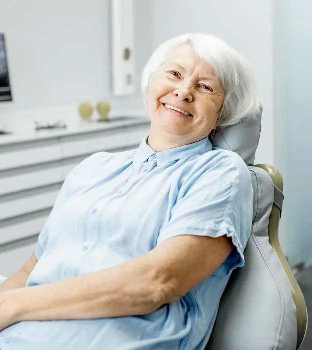 Smiling senior woman relaxing in dental chair after emergency treatment in Orlando office.