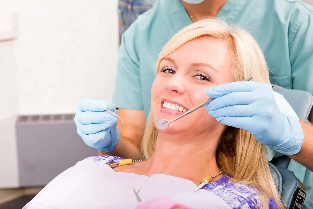 Dentist examines patient's smile during dental restoration treatment in Orlando.