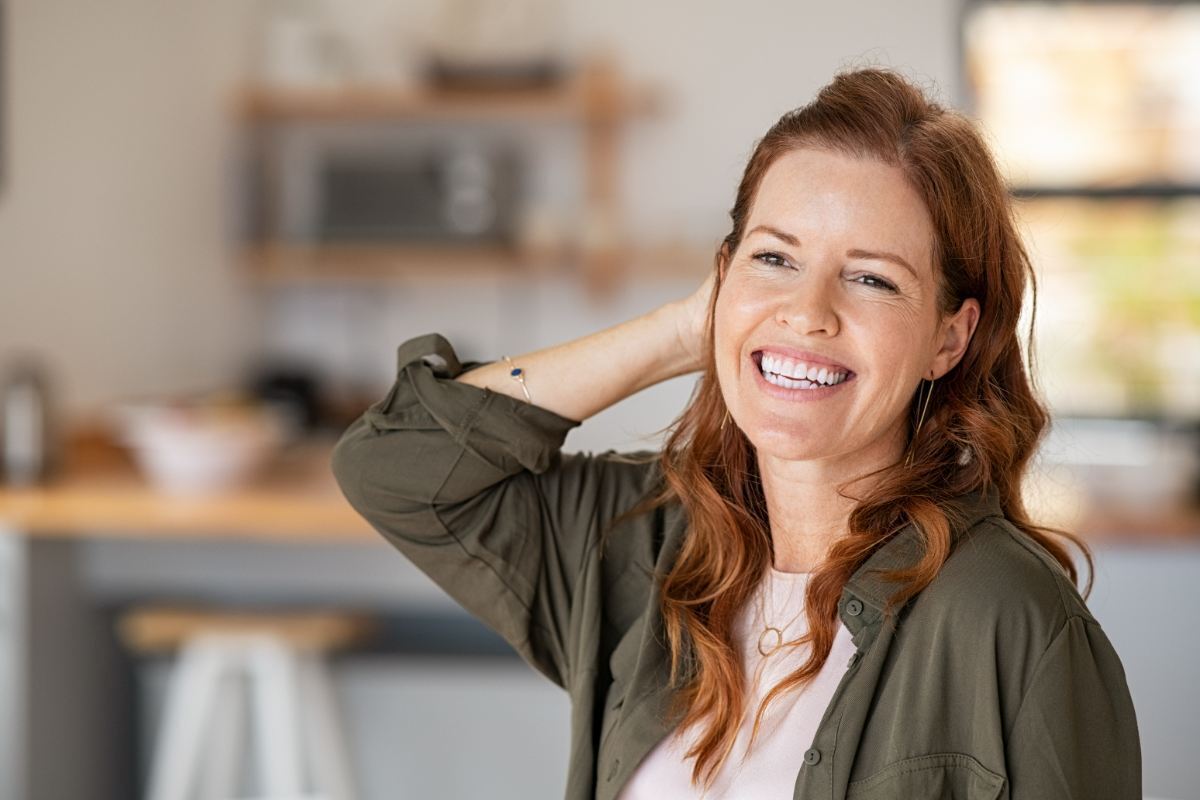 Woman with a natural-looking smile in a modern dental office setting.