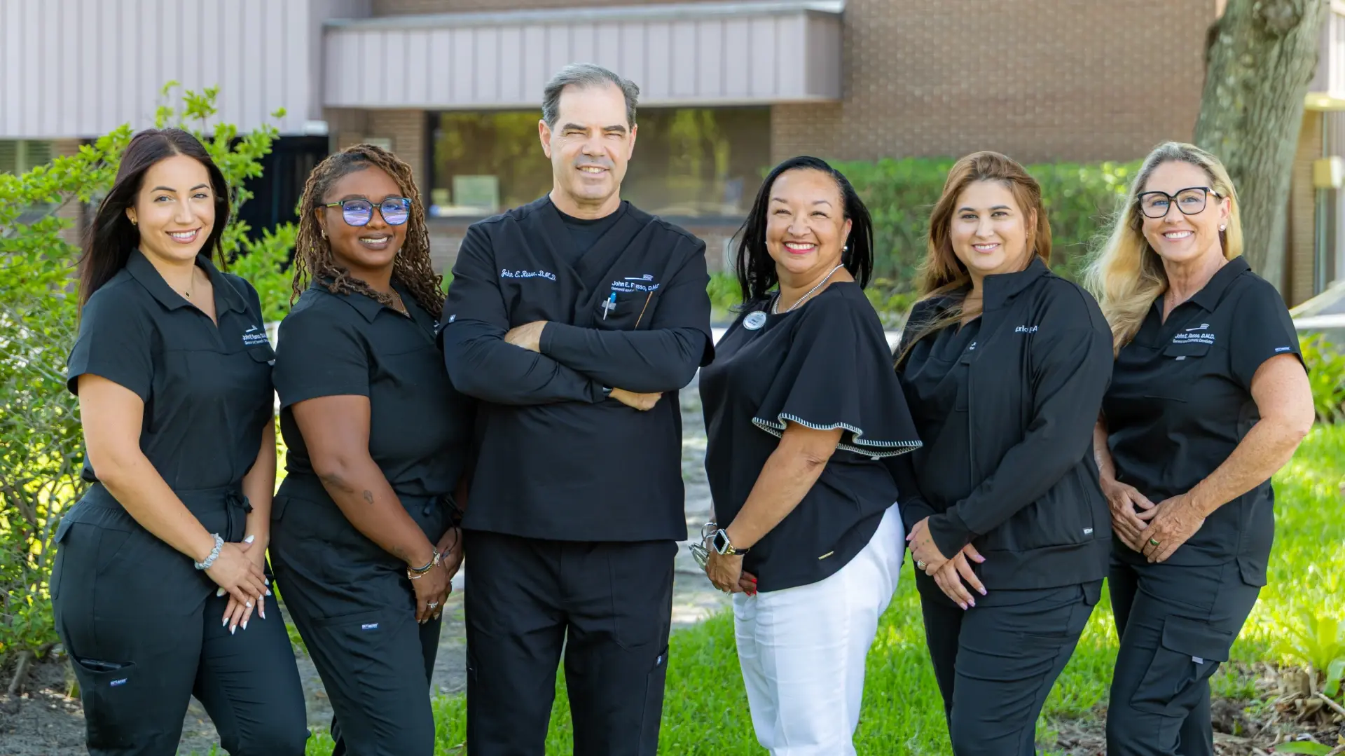 Dr. Castro and team smiling outside their Orlando dental practice on Mills Avenue.