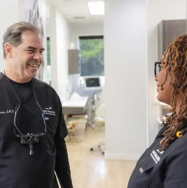 Dentist smiling while consulting with patient in modern Orlando dental office.