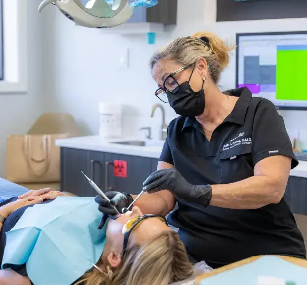 Dentist performing professional dental cleaning on patient in Orlando dental office.